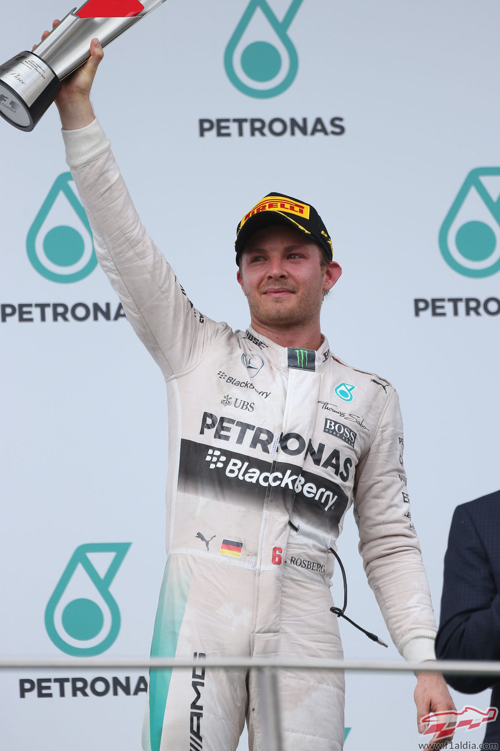 Nico Rosberg alza el trofeo desde el tercer escalón del podio de Sepang