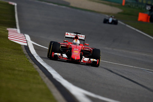 Sebastian Vettel seguido a lo lejos por uno de los Force India