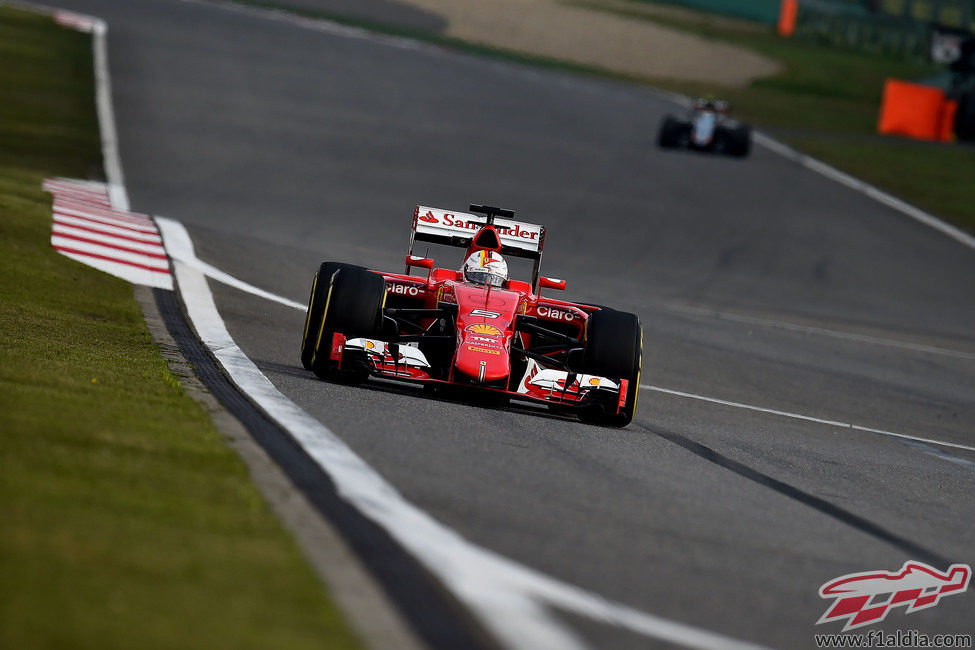 Sebastian Vettel seguido a lo lejos por uno de los Force India