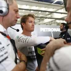 Nico Rosberg relajado en su box mientras sus ingenieros conversan