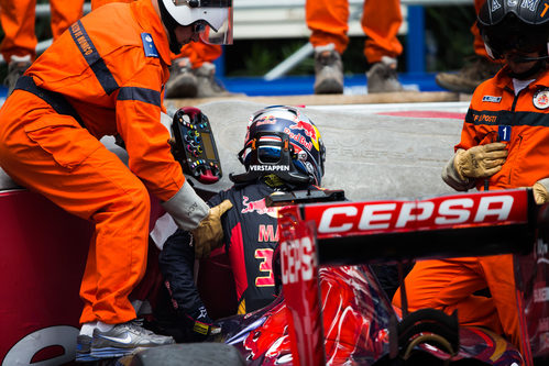 Los comisarios ayudan a salir del coche a Max Verstappen