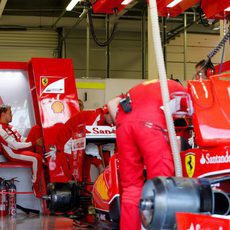 Sebastian Vettel en el box de Ferrari mientras el equipo trabaja