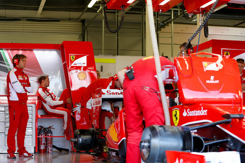 Sebastian Vettel en el box de Ferrari mientras el equipo trabaja