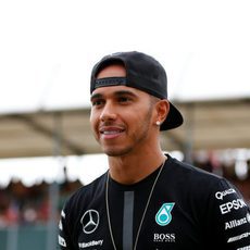 Un sonriente Lewis Hamilton pasea en el pitlane