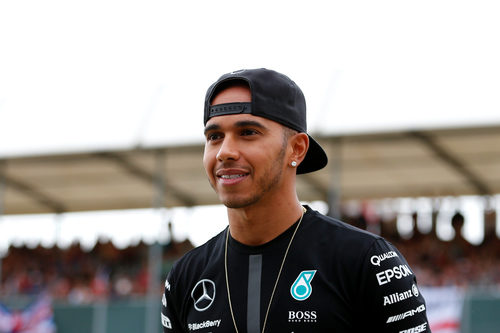 Un sonriente Lewis Hamilton pasea en el pitlane