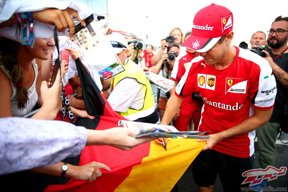 Sebastian Vettel firma la bandera a los aficionados