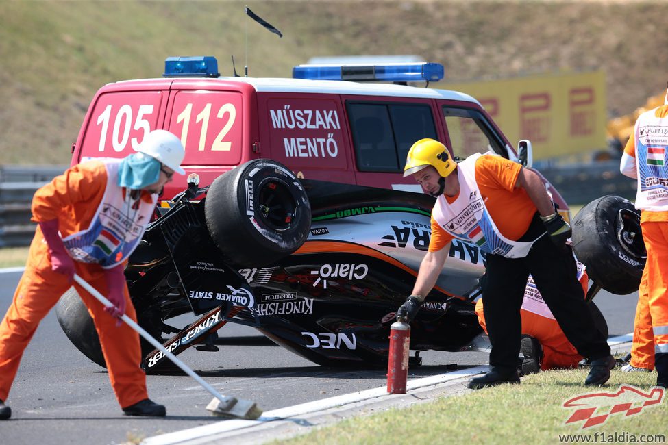 Los comisarios limpian la zona del accidente de Sergio Pérez