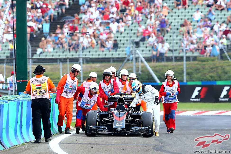 Los comisarios acudieron a ayudar a Fernando Alonso