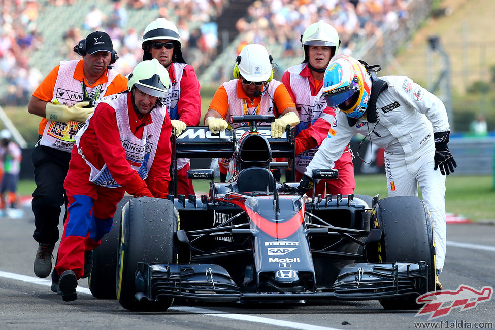 Fernando Alonso empuja su coche hasta el pitlane