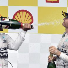 Lewis Hamilton moja a Nico Rosberg en la celebración de su victoria