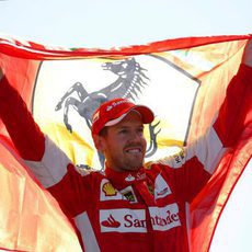 Sebastian Vettel sostiene la bandera de Ferrari