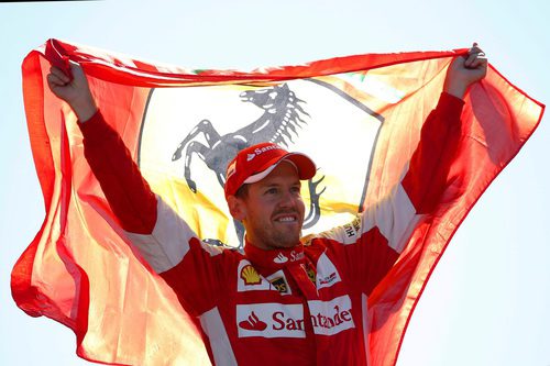 Sebastian Vettel sostiene la bandera de Ferrari