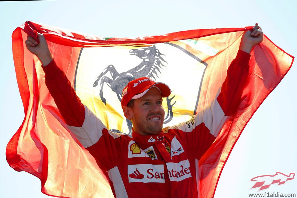 Sebastian Vettel sostiene la bandera de Ferrari