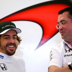 Fernando Alonso y Eric Boullier sonríen en el box