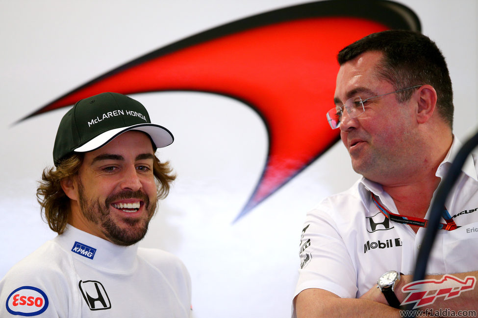Fernando Alonso y Eric Boullier sonríen en el box