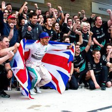 Lewis Hamilton festeja con su bandera el tercer título