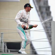 Lewis Hamilton lanza champán en el podio