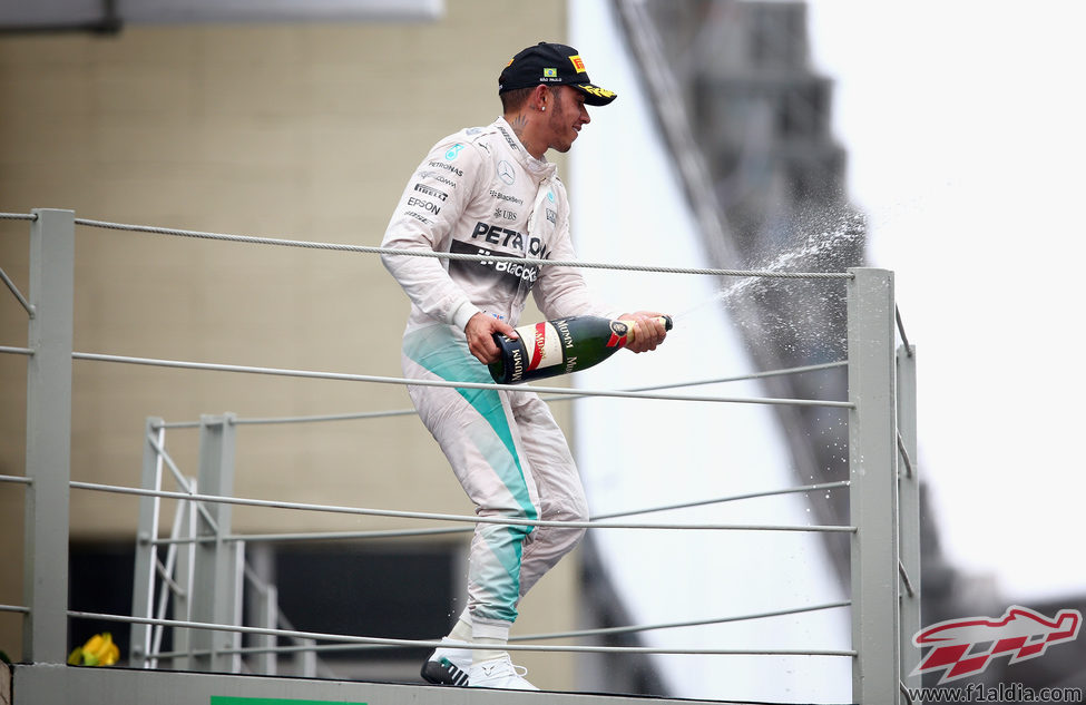 Lewis Hamilton lanza champán en el podio