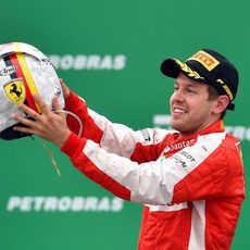 Sebastian Vettel sostiene su casco en el podio