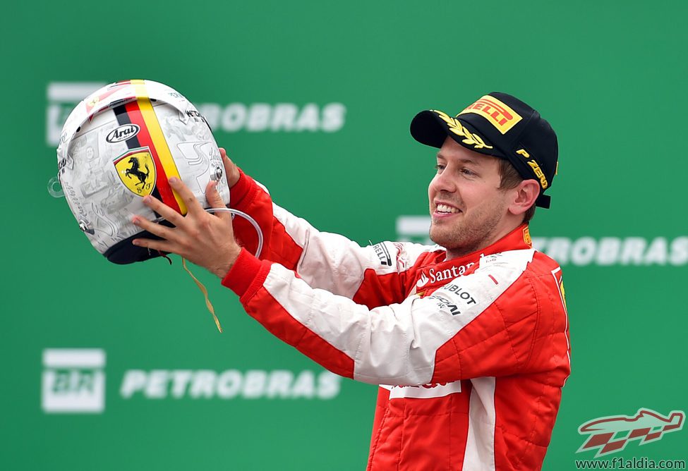 Sebastian Vettel sostiene su casco en el podio