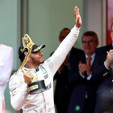 Lewis Hamilton saluda con el trofeo en la mano
