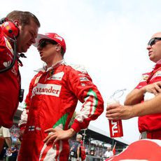 Kimi Räikkönen charla con su equipo antes de la carrera