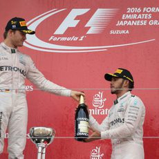 Nico Rosberg le pasa la botella a Lewis Hamilton