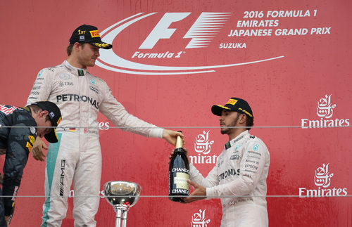 Nico Rosberg le pasa la botella a Lewis Hamilton