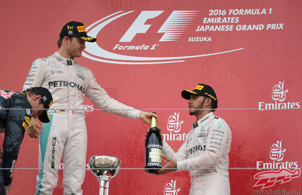 Nico Rosberg le pasa la botella a Lewis Hamilton