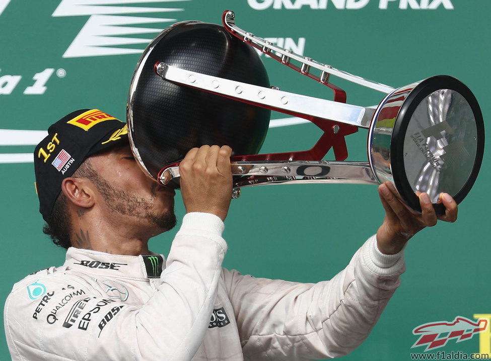 Lewis Hamilton bebe del trofeo ganador