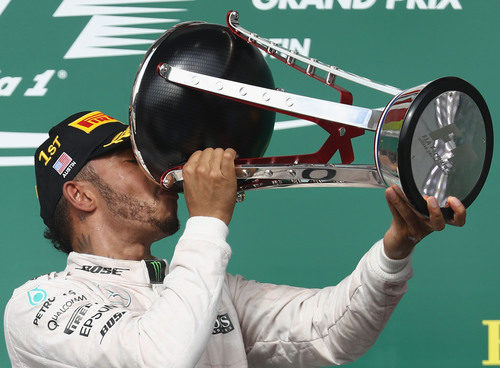 Lewis Hamilton bebe del trofeo ganador