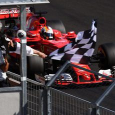 Vettel pasando junto a la bandera de cuadros