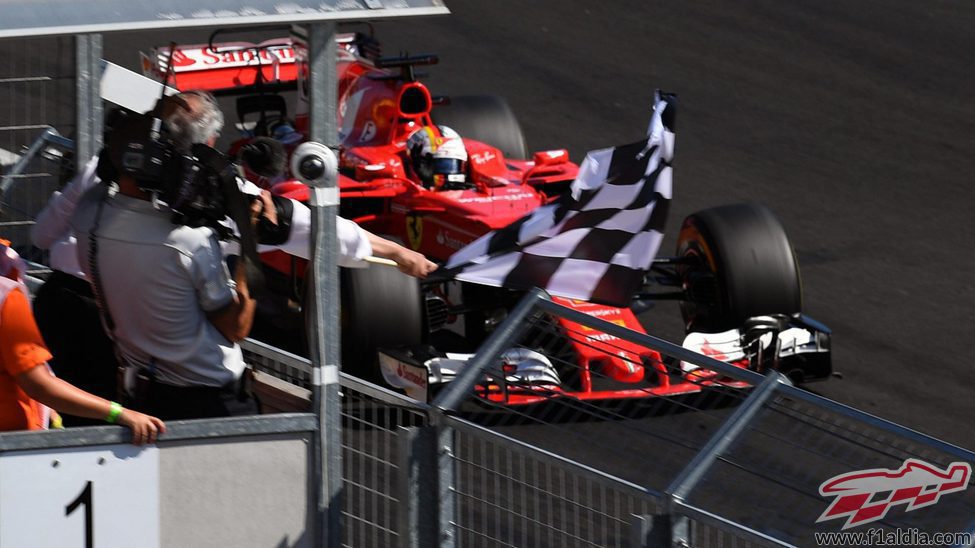 Vettel pasando junto a la bandera de cuadros
