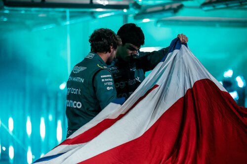 Los pilotos de Aston Martin mirando bajo la bandera