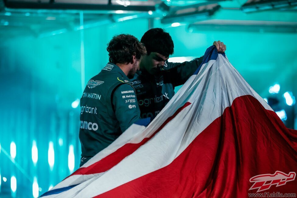 Los pilotos de Aston Martin mirando bajo la bandera