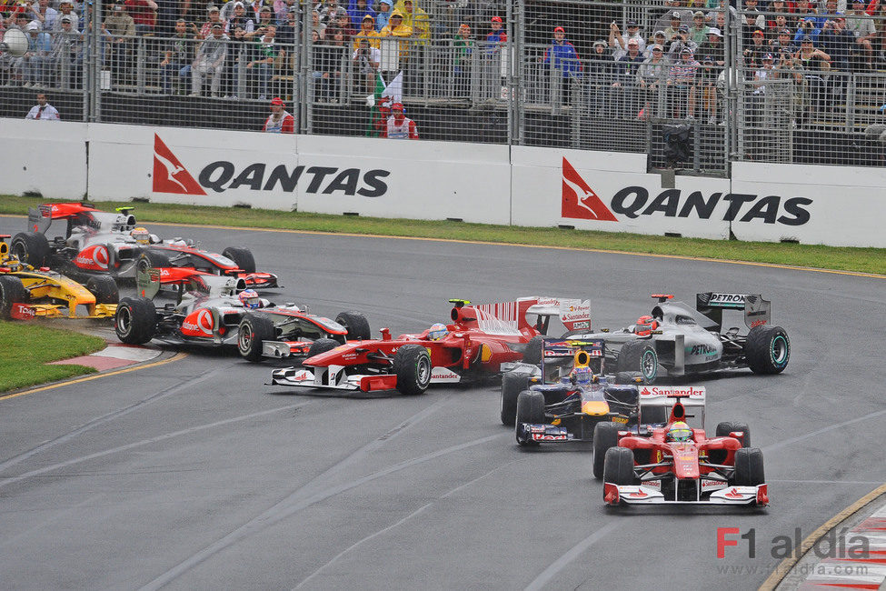 Fernando Alonso es tocado por Jenson Button en el primera curva