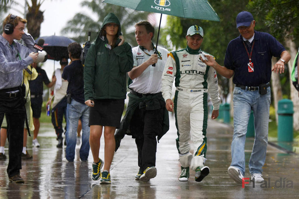 Heikki Kovalainen pasea por el lluvioso 'paddock' de Sepang
