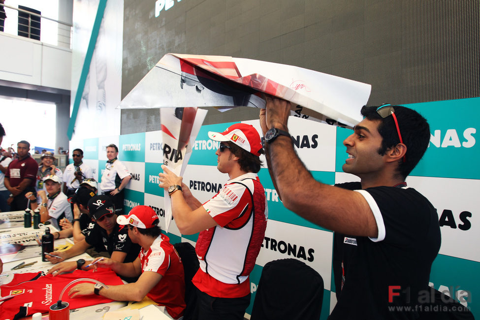 Alonso y Chandhok lanzan aviones de papel gigantes al público