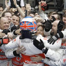 Button celebra la victoria con sus mecánicos y su novia