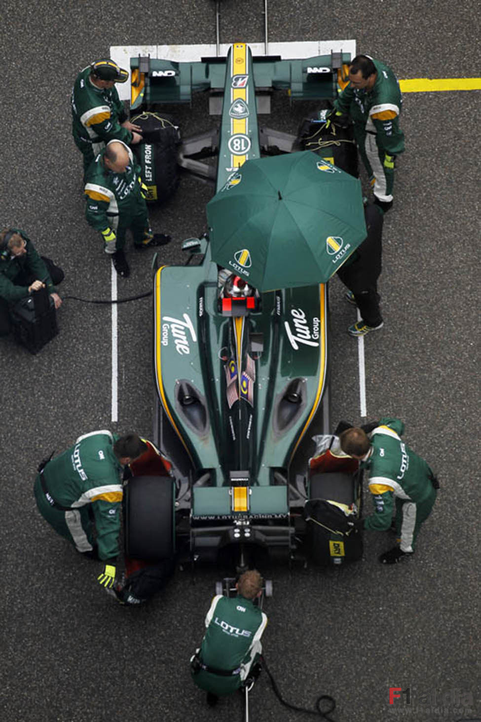 Los mecánicos de Lotus preparan el T127 en la parrilla de Shanghai