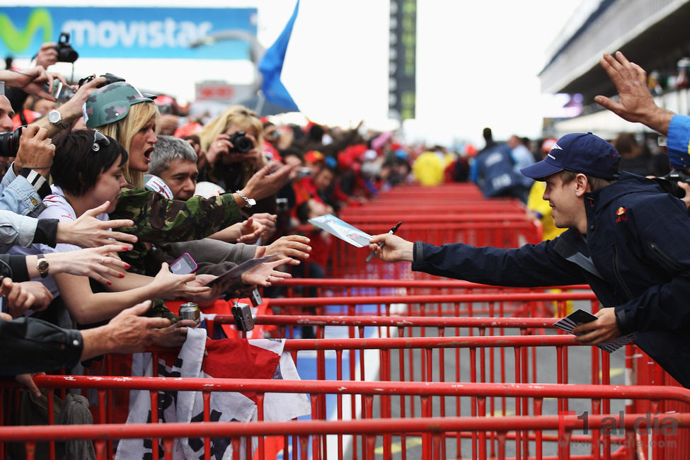Sebastian Vettel firma autógrafos para los aficionados