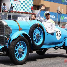 Adrian Sutil saluda al público español sobre un coche clásico