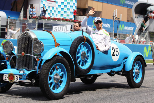 Adrian Sutil saluda al público español sobre un coche clásico