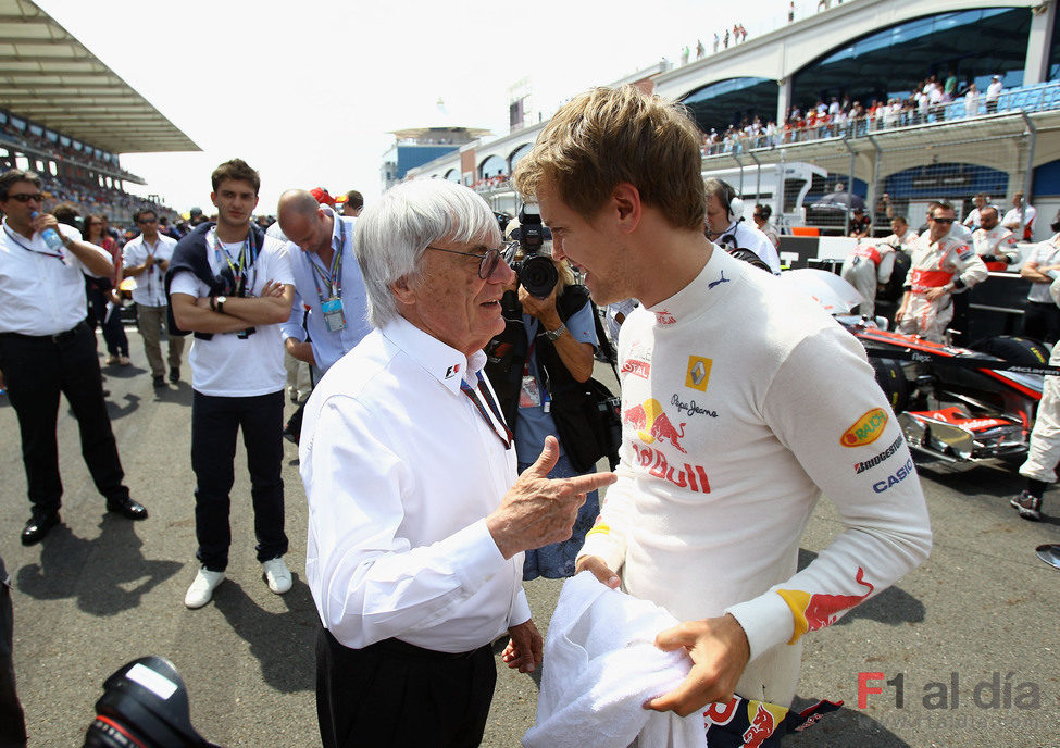 Ecclestone habla con Vettel en la parrilla