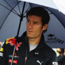 Mark Webber se cubre con un paraguas