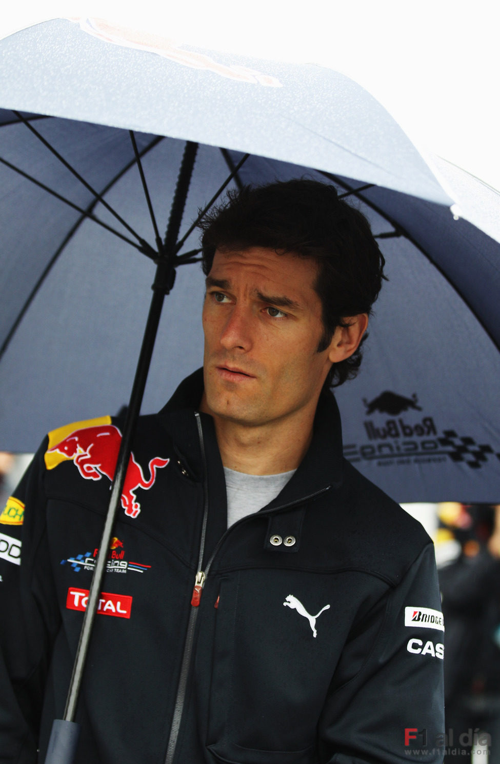 Mark Webber se cubre con un paraguas