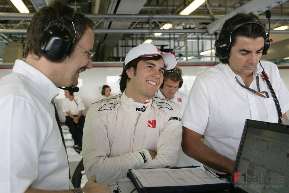 Sergio Pérez sonríe junto a sus ingenieros