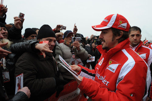 Alonso reparte fotos suyas firmadas