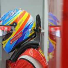 Fernando Alonso espera en su box con el casco puesto