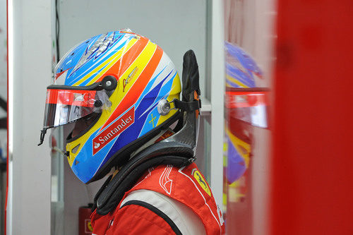 Fernando Alonso espera en su box con el casco puesto